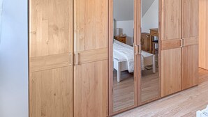 Ein Schlafzimmer mit Holzschrank, Bett, Nachttisch und Stuhl.