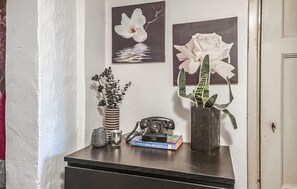 Un escritorio con un teléfono, un libro y dos jarrones con plantas.
