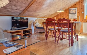 A wooden interior with a dining table, chairs, a television, and a poster on the wall. - Awesome home in Uddevalla with sauna (Uddevalla)