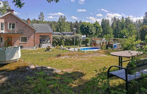 Il s’agit d’une propriété résidentielle comprenant une maison en briques, une piscine et un jardin.