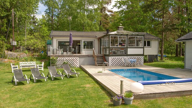 A house with a pool, deck chairs, and a covered patio area. - Gorgeous home in Värmdö (Värmdö)