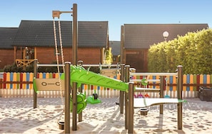 Ein Spielplatz mit Schaukeln, Rutschen und einer Kletterkonstruktion.