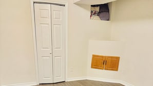 A room with a wooden floor, a white door, and a small wooden cabinet. - Spacious, Private & Independent Stay in Milton (Milton)