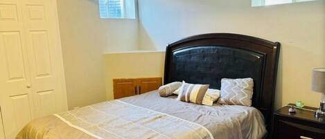 Ein Schlafzimmer mit Bett, Nachttisch und Fenster.