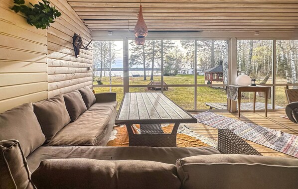A covered patio with a wooden bench, a sofa, and a table. - 2 bedroom stunning home in Kristinehamn (Kristinehamn)