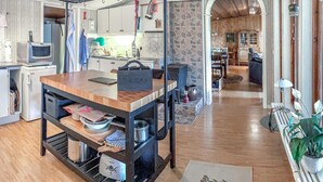 Een keuken met een houten aanrecht, een inbouwoven en een stenen muur.