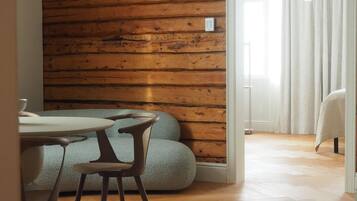 Comedor con pared de madera, una lámpara de araña y vistas a otra habitación.