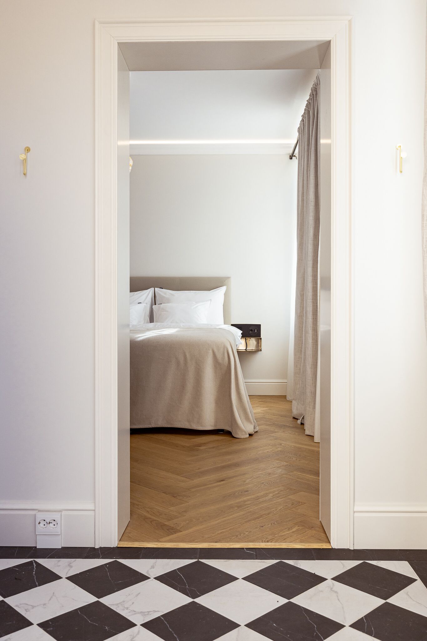 Una camera da letto con un letto, un comodino e un pavimento in legno.
