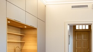 A modern kitchen with built-in cabinets, a stainless steel sink, and a herringbone wood floor. - Sugar Factory Apartments (Kotka)