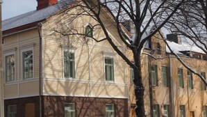 A multi-story building with a corner entrance, large windows, and a tree in front. - Sugar Factory Apartments (Kotka)