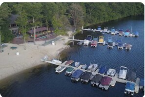 A marina with boats docked, a sandy beach, and a building with a red roof. - Family-Friendly 4BR Near Big Boulder w Lake & Mountain Access + Fireplace + Pets (Lake Harmony)