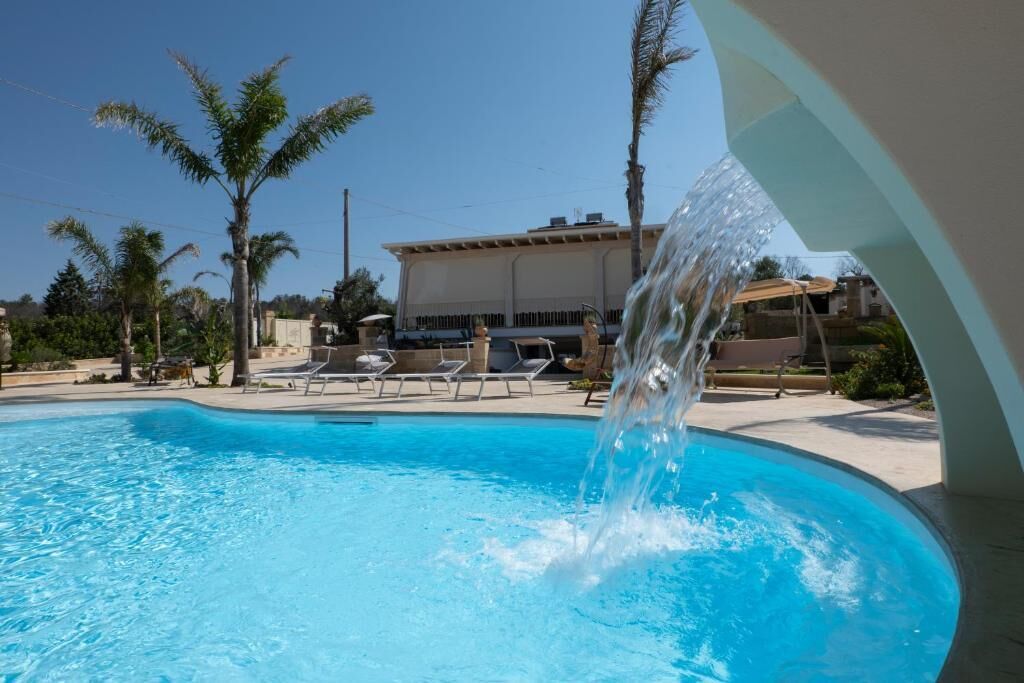 Una piscina al aire libre de temporada, sombrillas, tumbonas