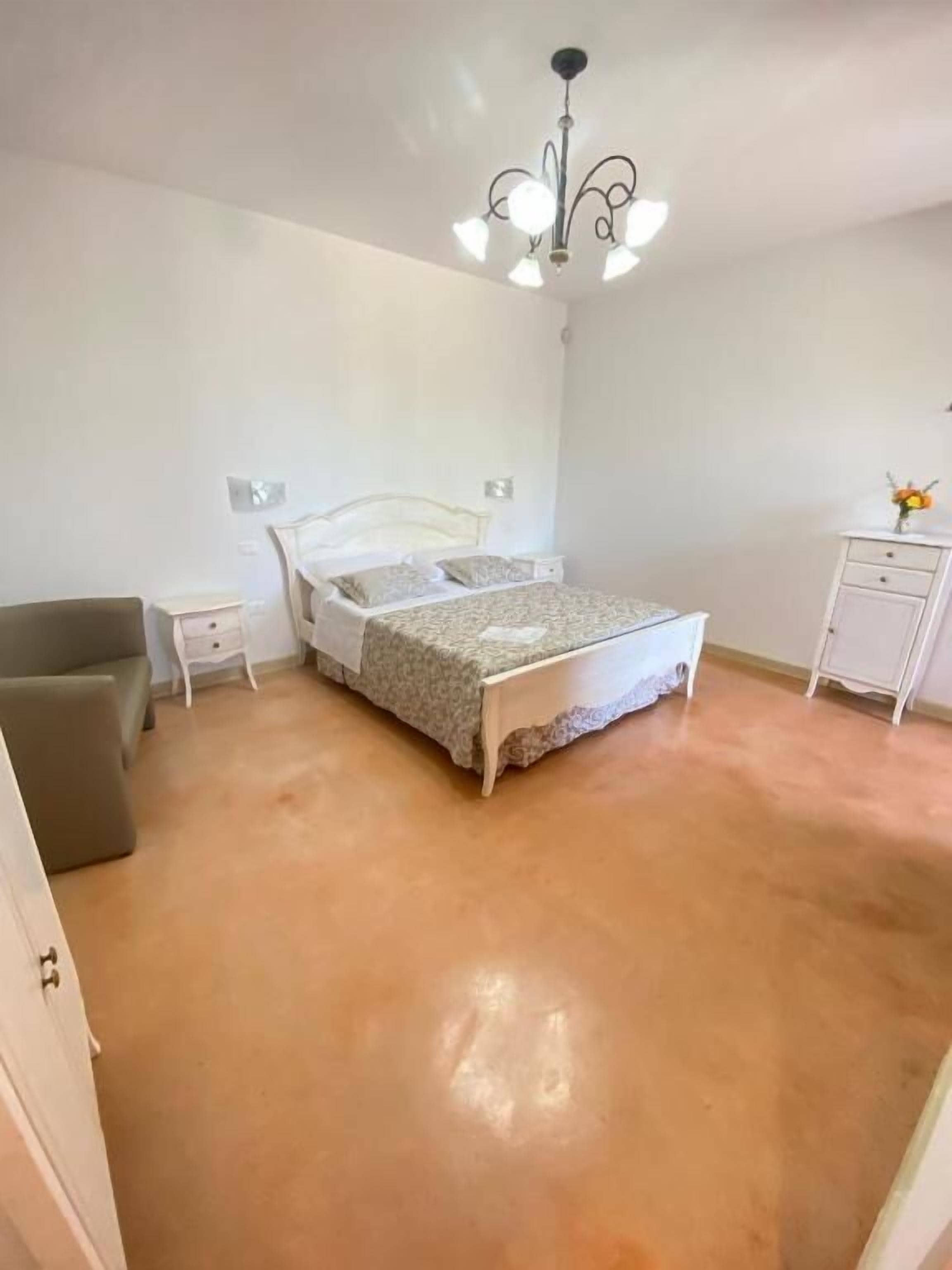 Une chambre à coucher avec un lit, une table de chevet, une commode et une chaise.