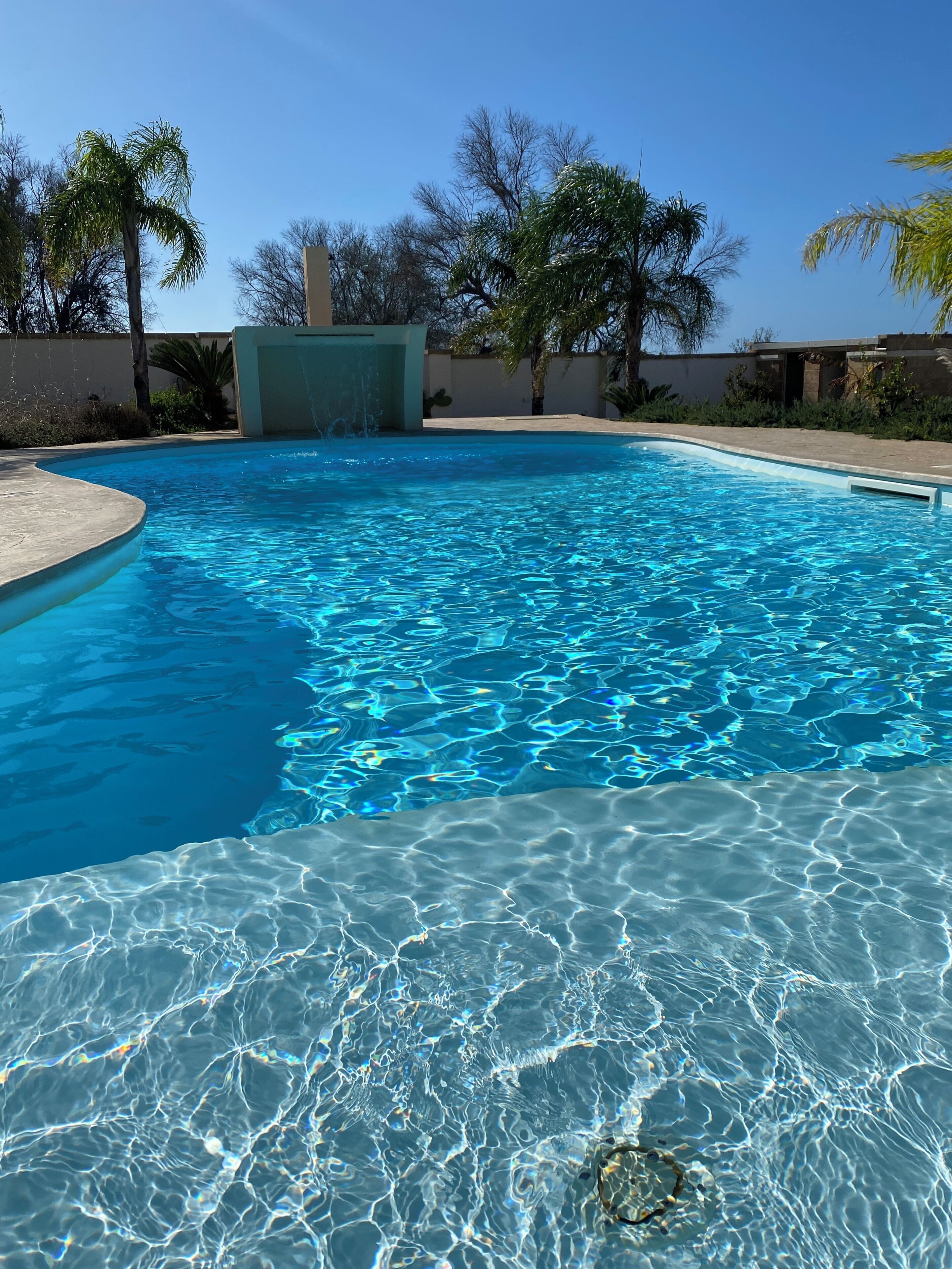 Una piscina al aire libre de temporada, sombrillas