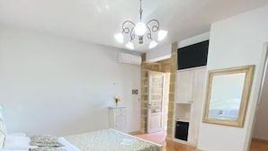 Un dormitorio con cama, escritorio, silla, armario y ventana.