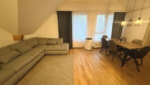 Una sala de estar moderna con un sofá modular, una mesa de comedor con sillas y una mesita auxiliar.
