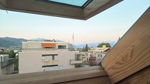 Un tragaluz con vista a edificios modernos y montañas.