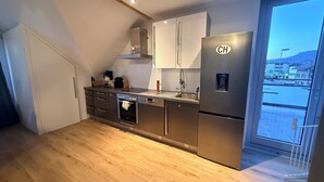 Una cocina moderna con electrodomésticos de acero inoxidable, horno empotrado y refrigerador.