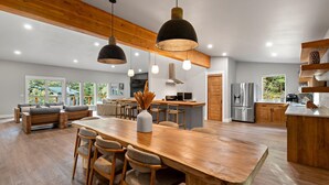 A spacious kitchen with wooden countertops, a central island, and pendant lighting. - Alaska Adventure Retreat LUXURY 4 Bed 5 bath in Girdwood, Base of Alyeska Resort (Anchorage)