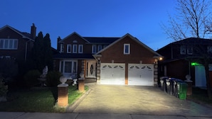 Una casa residenziale con vialetto, garage e un prato curato.