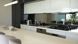 Una cocina moderna con una isla central, electrodomésticos de acero inoxidable y un diseño elegante.
