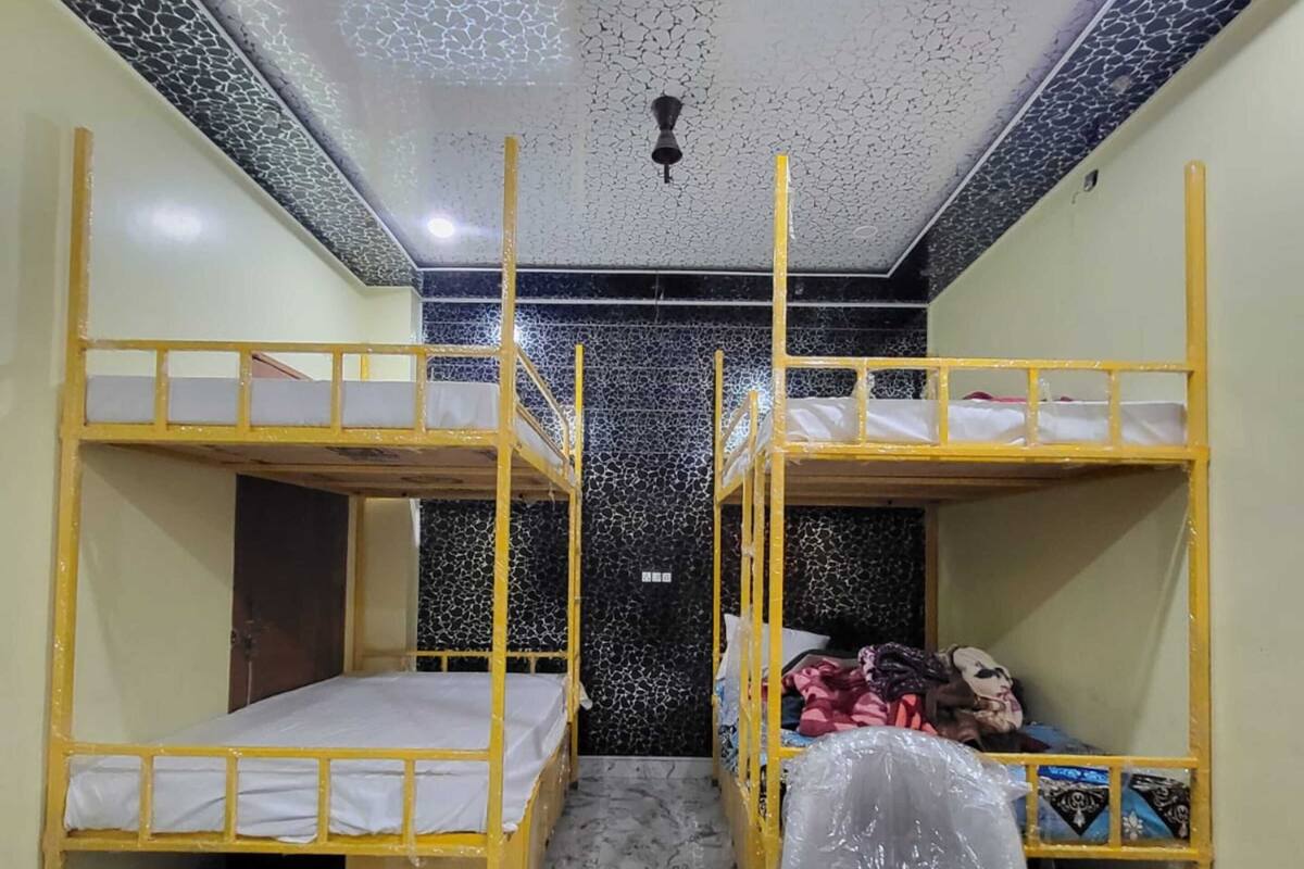 A room with bunk beds, a desk, and a chair.