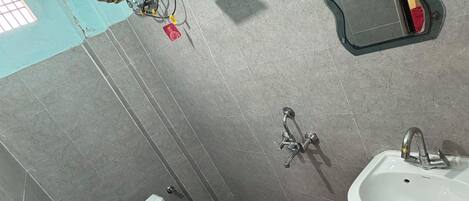 A bathroom with a toilet, sink, mirror, and shower.