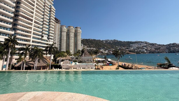 Ein Resort mit Schwimmbad, Strandbereich und Hochhäusern.
