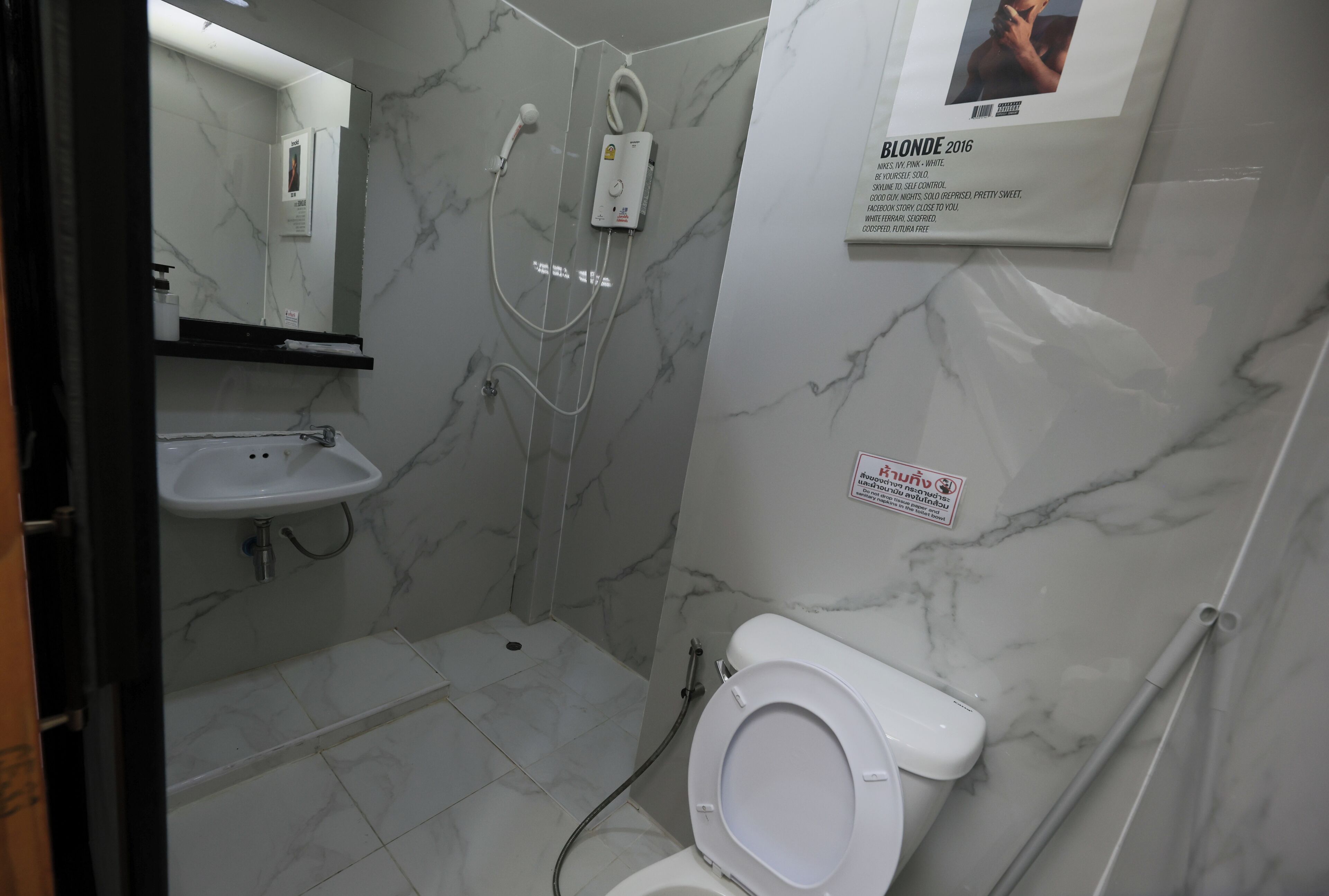 A bathroom with a toilet, sink, and shower.