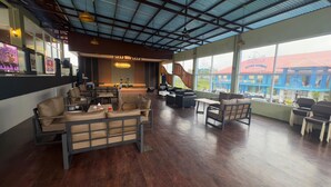 A spacious lounge area with leather sofas, a bar area, and large windows offering views of the city. - Gorgeous 3-bedroom villa in cool Wonosobo for relaxing stays (Wonosobo)