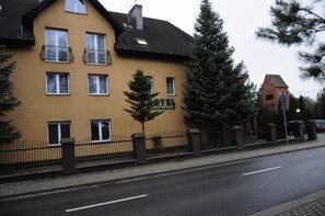 Een gebouw met twee verdiepingen, met een bord waarop 'HOTEL' en 'CICLIFIC' staat, wat aangeeft dat het een fietsvriendelijke gelegenheid is.