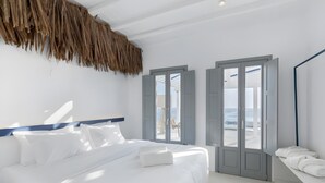 Ein modernes Hotelzimmer mit Bett, großem Fenster und Blick auf den Strand.