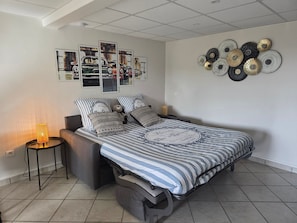 Ein Schlafzimmer mit Bett, Nachttisch, Lampe und Wanddekorationen.