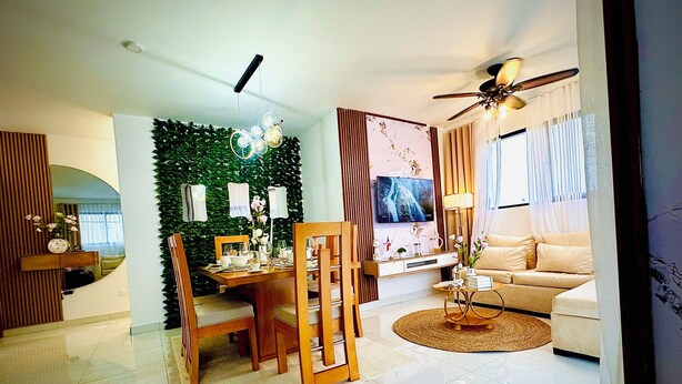 Ein modernes Wohnzimmer mit Essbereich, Deckenventilator und Fernseher.