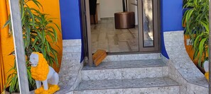 Una escalera conduce a una habitación con vistas al exterior, un reposapiés de cuero marrón y una estatua de león.