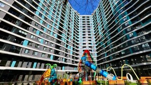 Un edifici d'apartaments modern amb una zona de jocs a la façana.
