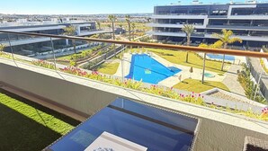 A rooftop pool with a glass balustrade, a clear view of the cityscape, and modern buildings in the background. - Apartment TM lagoons Village 141 (Torrevieja)