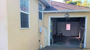 A house with a garage, a stone patio, and a window.