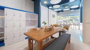 Un interior moderno con una mesa de madera, sillas, un sofá y vistas al exterior.