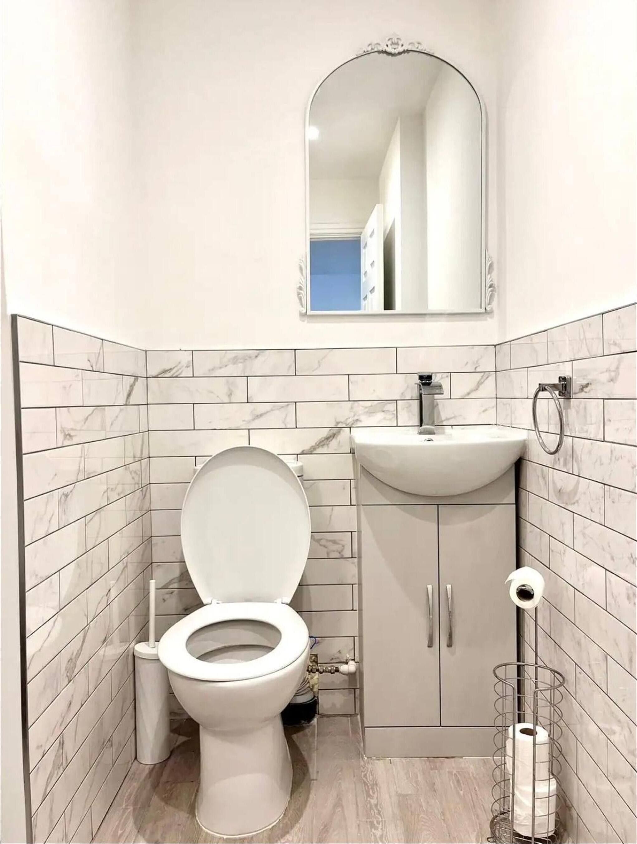 Ein Badezimmer mit Toilette, Waschbecken und Spiegel.