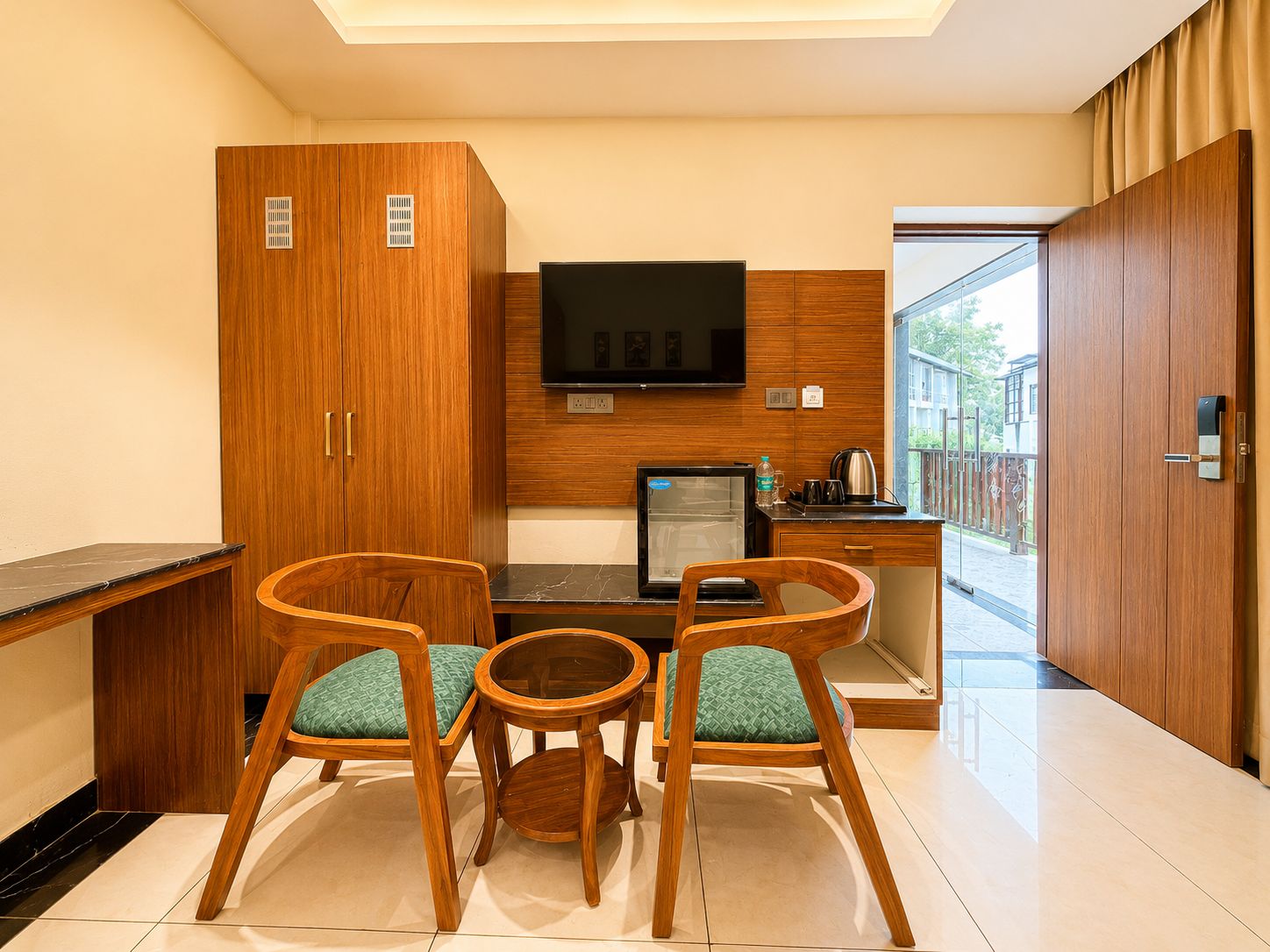 A modern kitchen with wooden cabinetry, a flat-screen TV, a refrigerator, and a coffee maker.