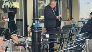 An outdoor cafe with tables and chairs, a sign reading 'CAFE AND RESTAURANT,' and a person standing near the entrance. - cosy 1bed perfect for family and contractors (Woolwich, London)