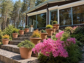 A house with a glass conservatory, stone steps, and potted plants. - Club Paradise Bay Iskar Lake (Dolni Pasarel)