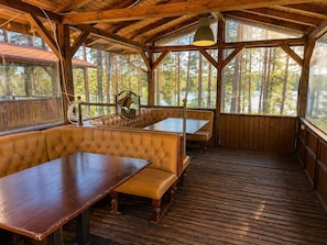 A wooden deck with a bench and table, large windows, and a view of trees. - Club Paradise Bay Iskar Lake (Dolni Pasarel)