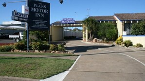 Ein Schild eines Motels, der Eingang eines Gebäudes und ein Parkplatz.