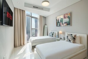 A hotel room with two beds, a TV, a painting, and a city view. - Chic 2BR in Paramount Midtown  (Dubai)
