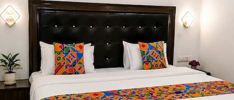 Un dormitorio moderno con una cama grande, un ventilador de techo e iluminación empotrada.