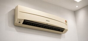Aire acondicionado instalado en la pared, con panel de control a la izquierda y etiqueta de marca a la derecha.