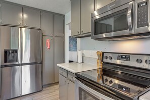 A kitchen with stainless steel appliances, including a refrigerator, microwave, and oven. - 1 Mi to Dtwn Palm Springs! Desert Escape w/ Pool (Palm Springs)