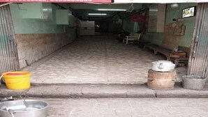 A narrow corridor with a bench, a yellow bucket, and metal containers on the floor. - SAH HAVELI 400m WALK TO KASHI VISHWANATH (Varanasi)